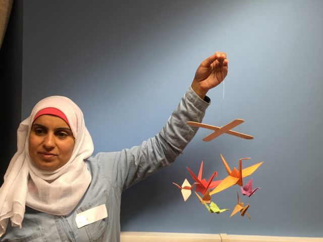 Refugee Action client holding their finished crane mobile