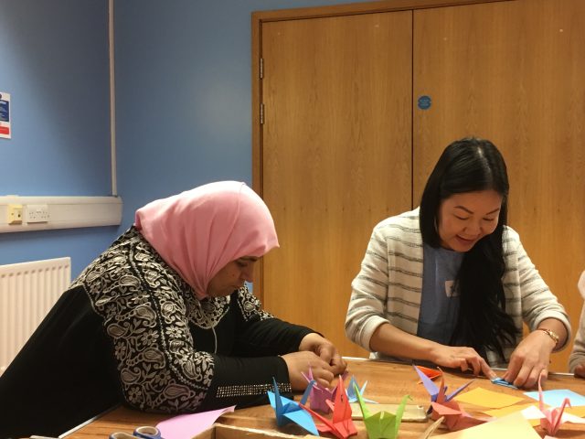 Shelanu member and Refugee Action client folding origami paper cranes