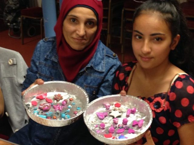 Mother and daughter are holding up their bowl with the clay pieces