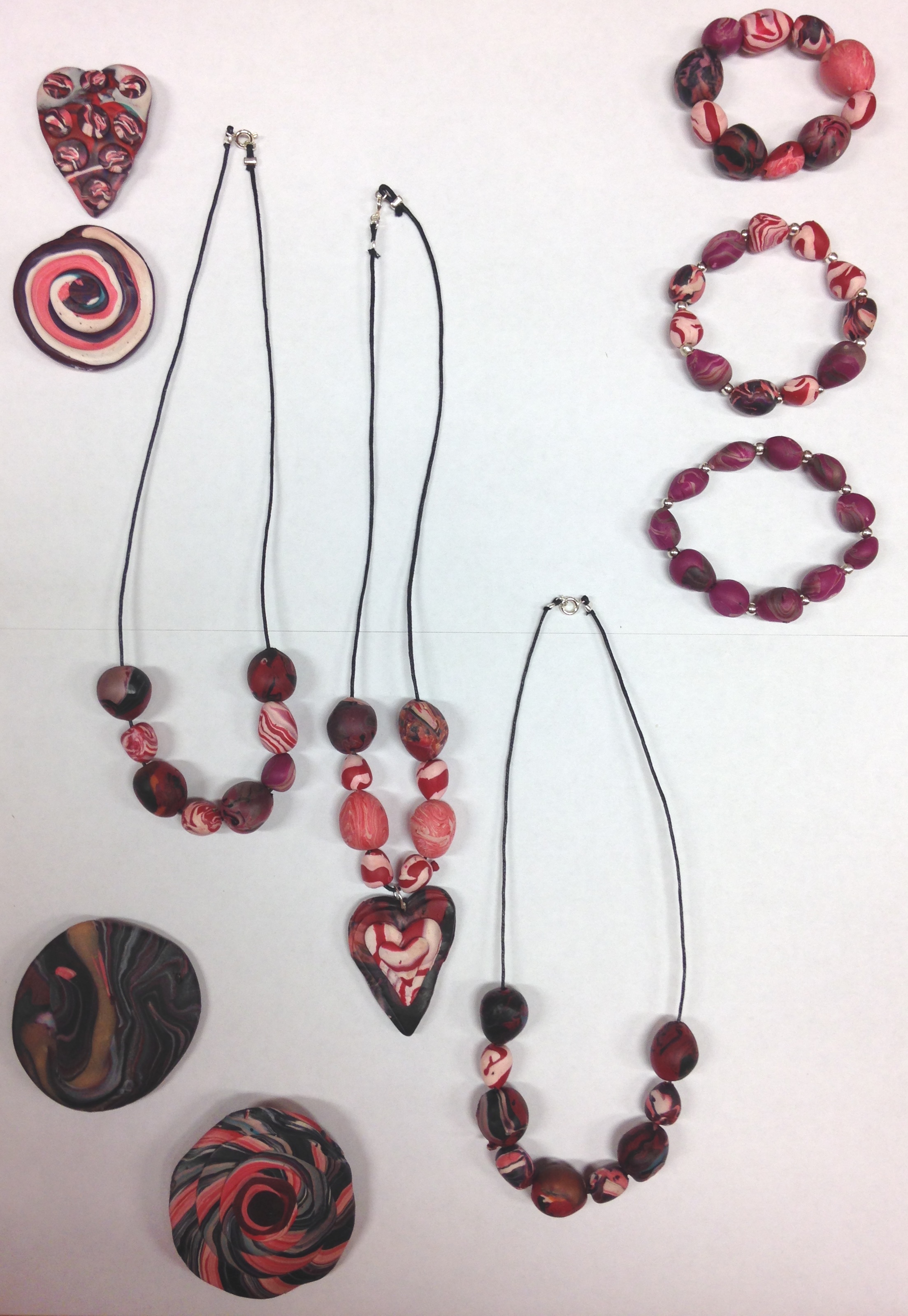 clay jewellery in the colours pink, red, black and white