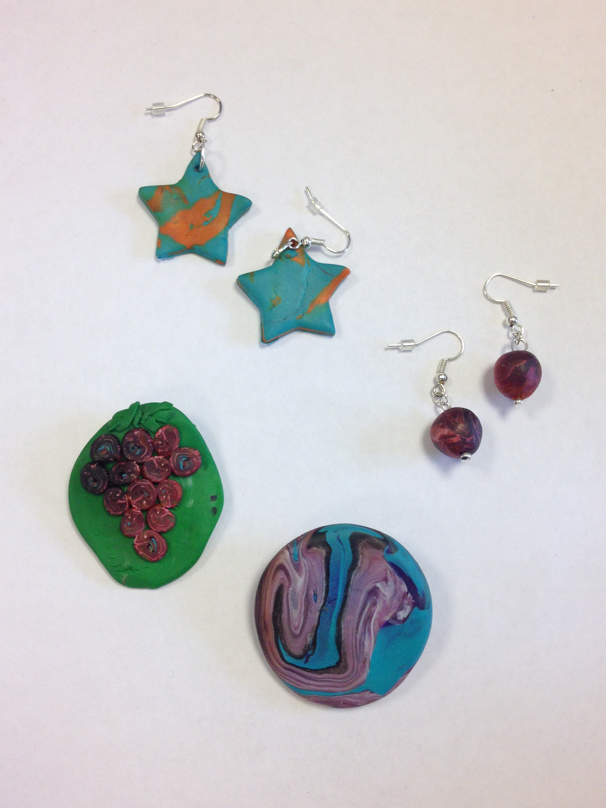 brooch with different colours and one with grapes; earrings as a shape of stars and balls