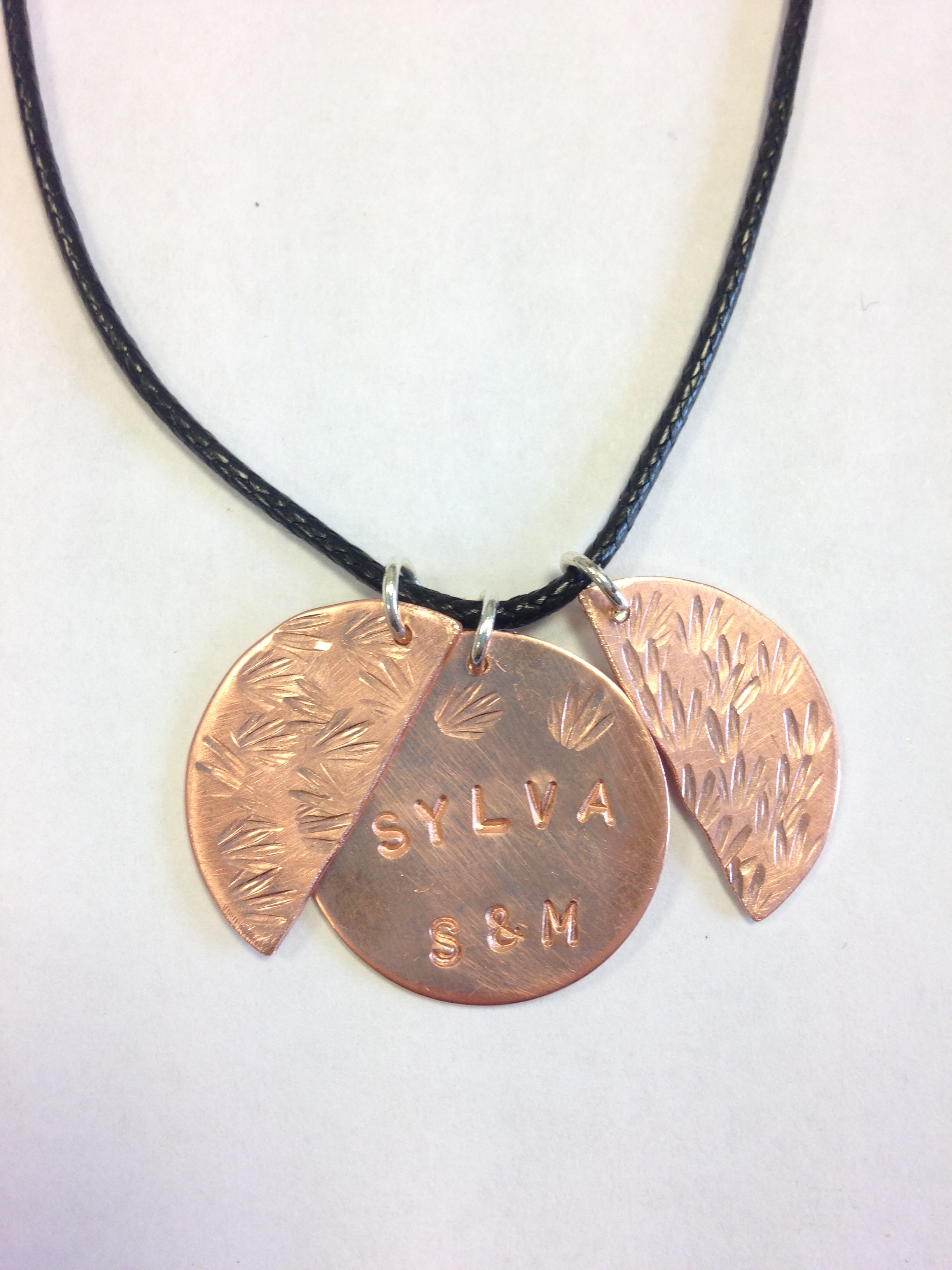 A necklace on whose copper disc a woman stamped her name.