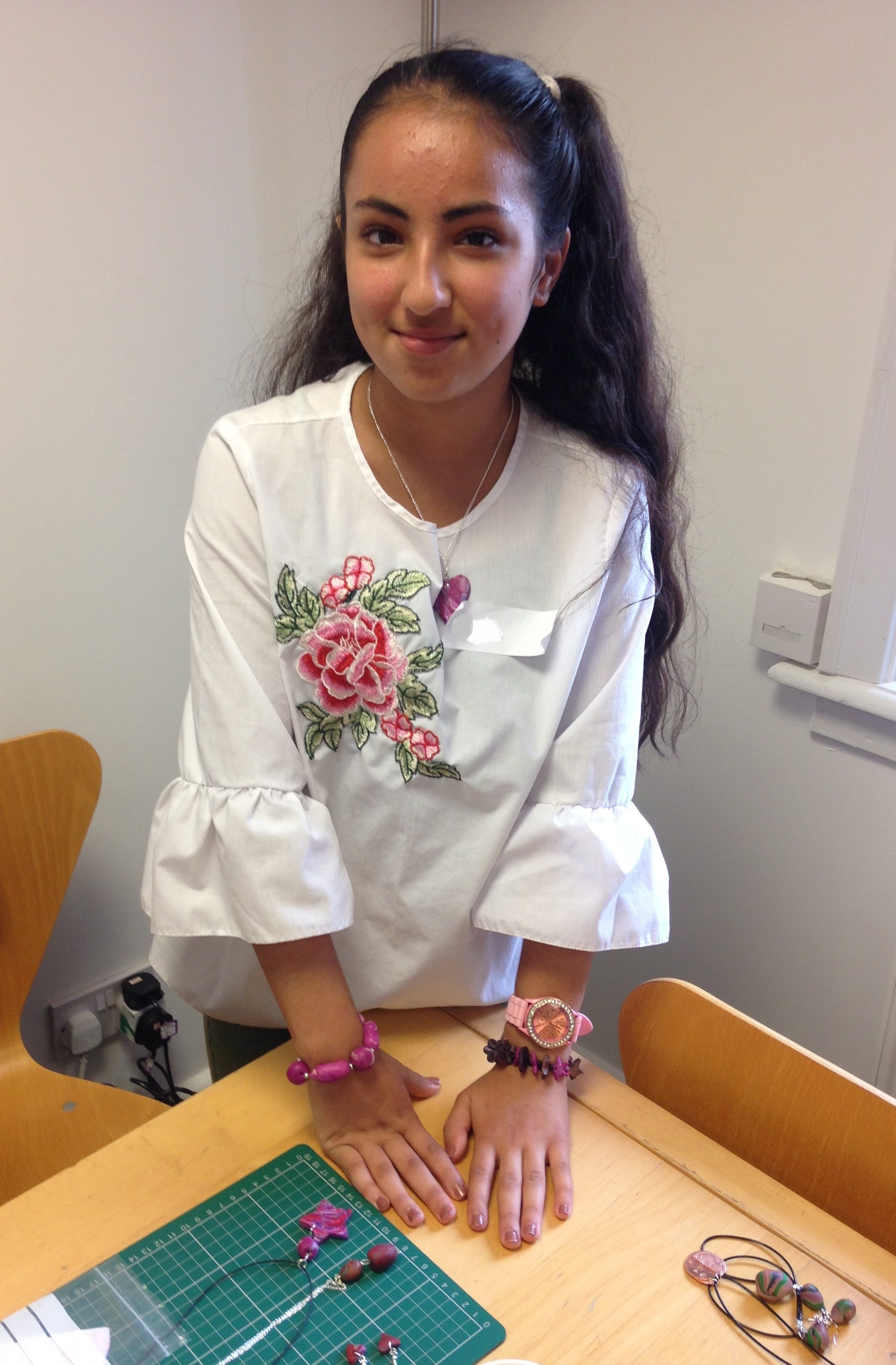 A girl of the refugee action group is fitting her clay jewellery pieces