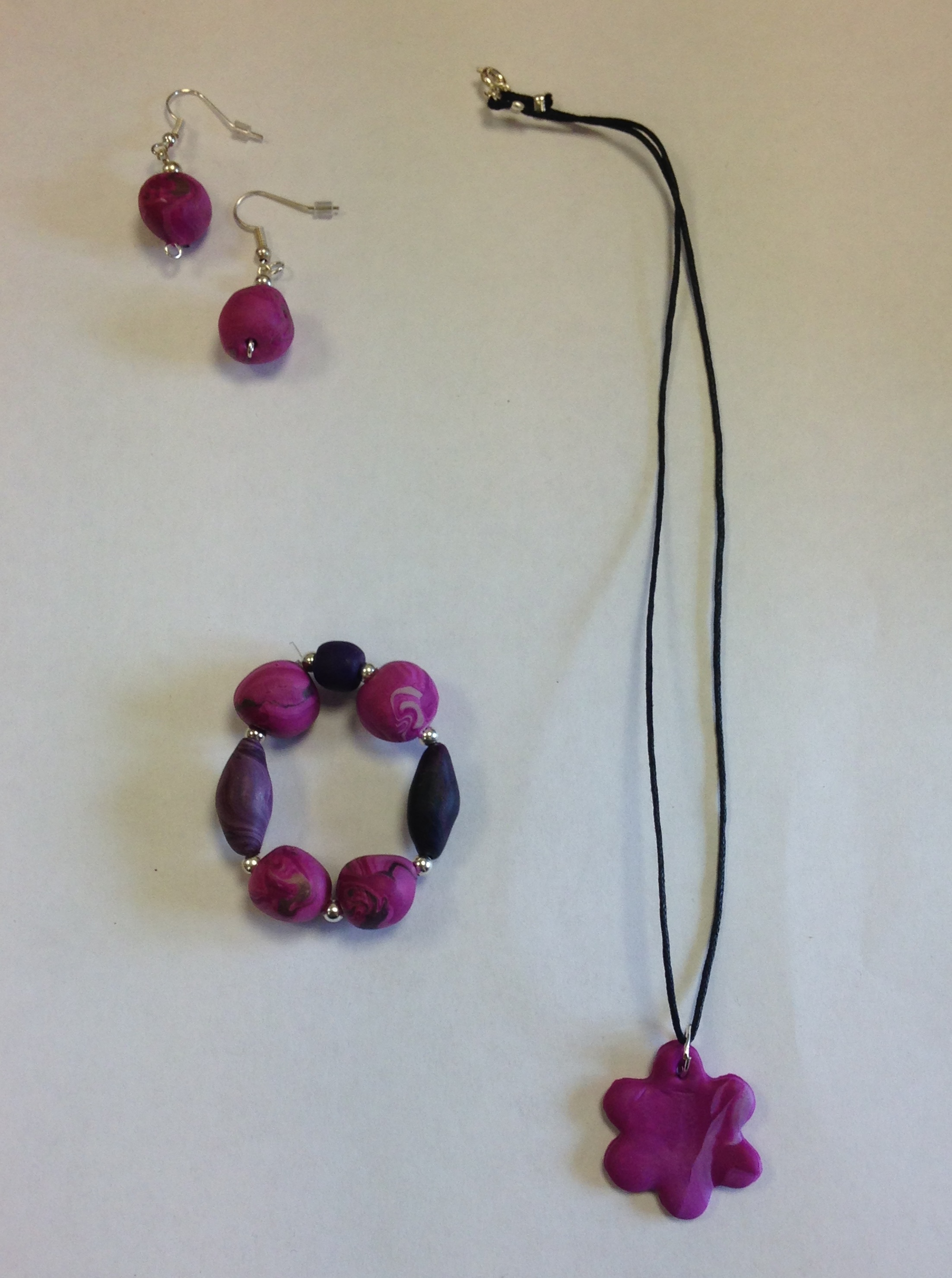 pink bracelet, earrings and a necklace with a pink flower as pendant