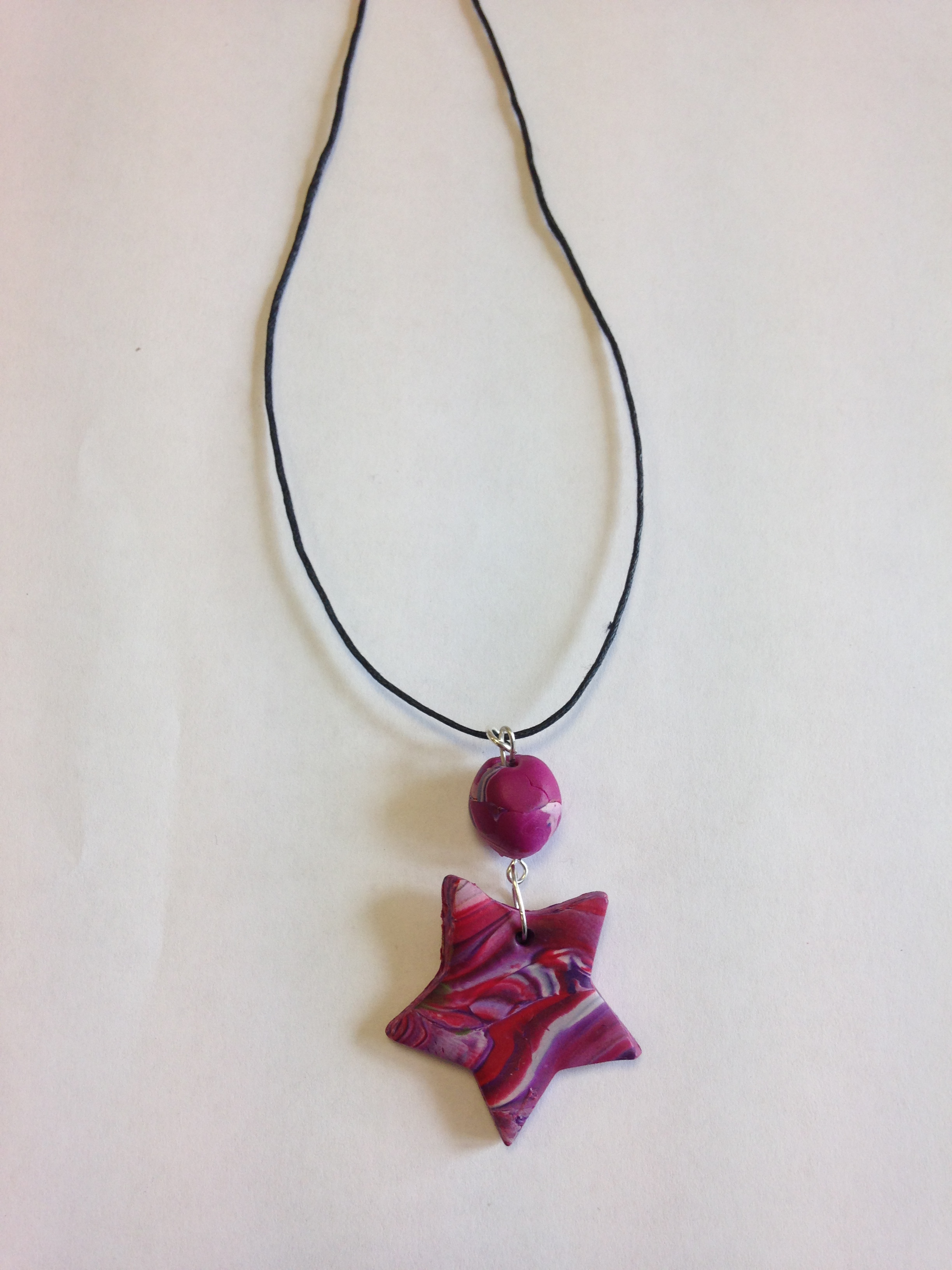 necklace with a pink ball and star as a pendant