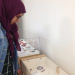 A lady looks at the jewellery the participants have made